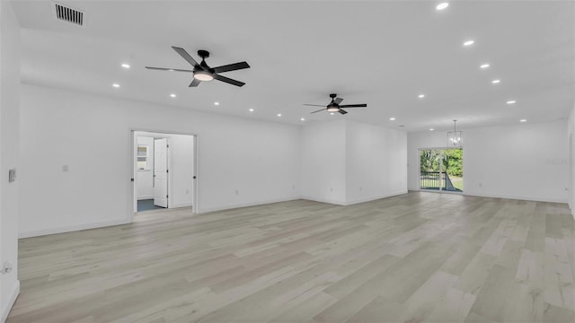 unfurnished living room featuring light wood finished floors, visible vents, ceiling fan with notable chandelier, and recessed lighting