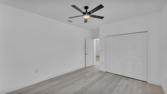 unfurnished bedroom featuring a closet, visible vents, light wood-style flooring, and baseboards