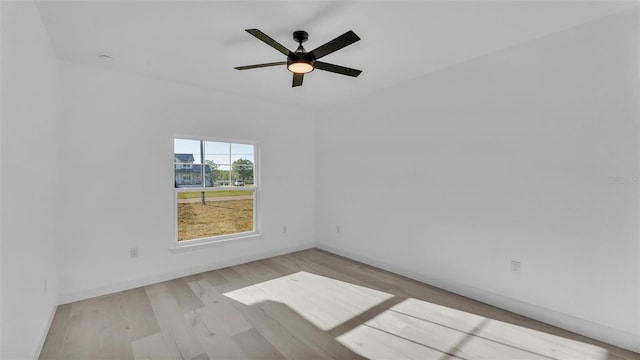 spare room with wood finished floors, baseboards, and ceiling fan