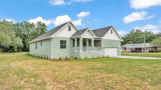 view of front of home with an attached garage, a porch, driveway, and a front lawn