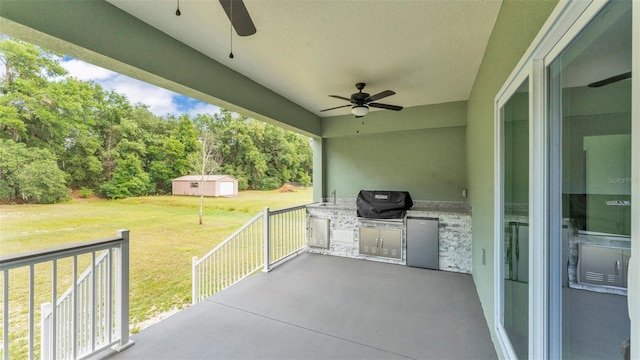 view of patio with a ceiling fan, an outbuilding, and area for grilling