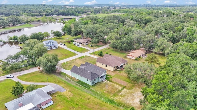 aerial view featuring a wooded view, a water view, and a residential view