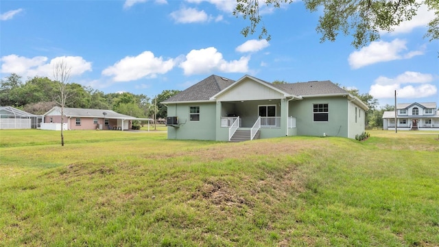 back of property with a yard and stucco siding