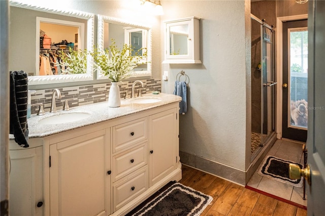811 W Heron Pl, Winter Haven, FL 33884 - bathroom with tasteful backsplash, wood-type flooring, a stall shower, double vanity, and a spacious closet