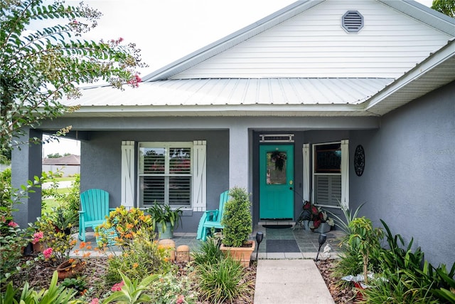 811 W Heron Pl, Winter Haven, FL 33884 - doorway to property with covered porch, stucco siding, and a metal roof