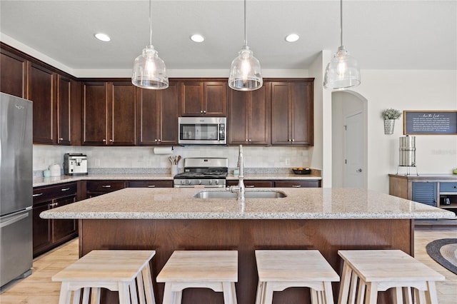 kitchen with dark brown cabinetry, a breakfast bar, and stainless steel appliances