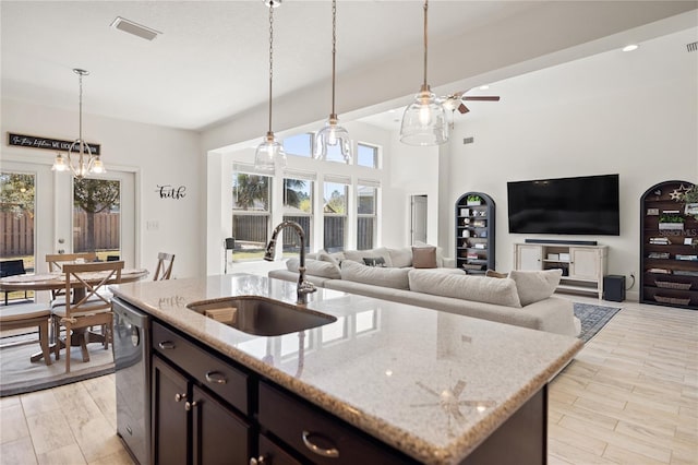 kitchen featuring visible vents, dishwasher, ceiling fan, a sink, and decorative light fixtures
