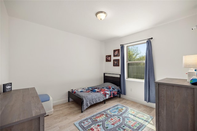bedroom with baseboards and wood finished floors