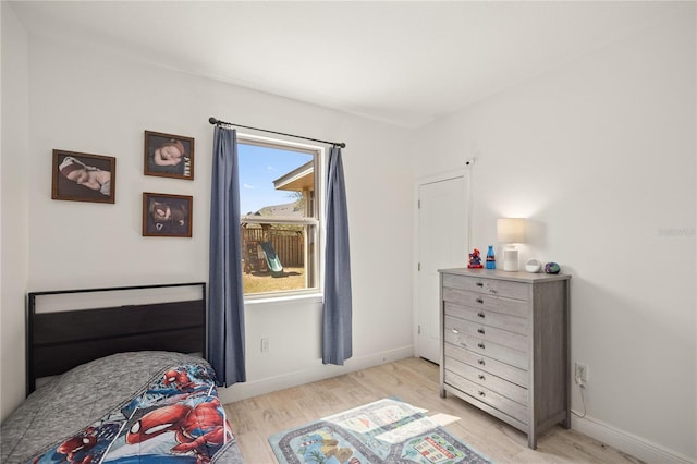 bedroom featuring baseboards and light wood finished floors