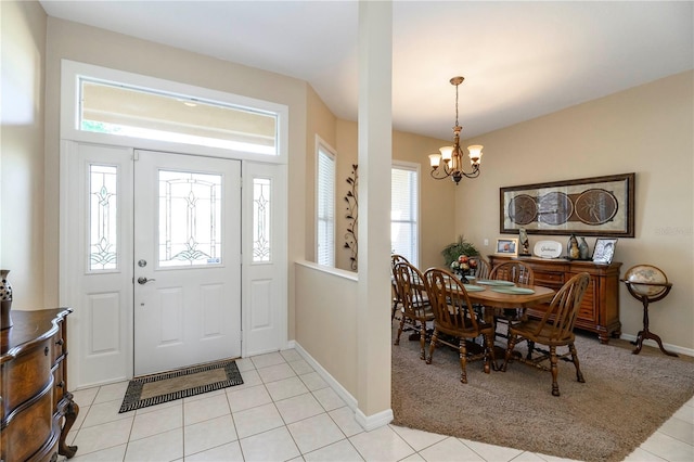 foyer entrance featuring baseboards, light tile patterned floors, and an inviting chandelier