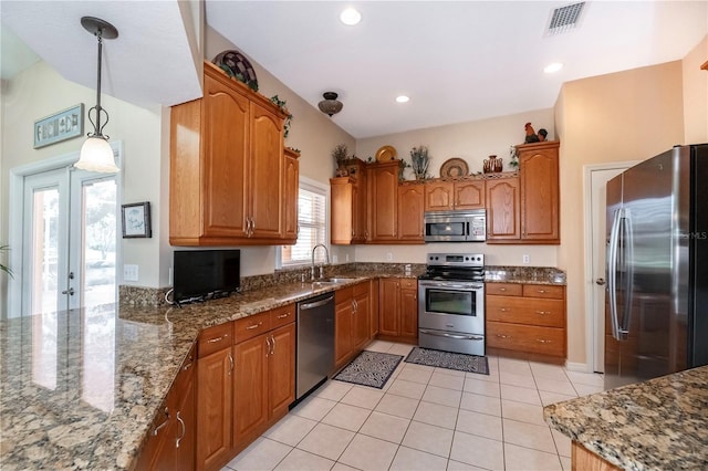 kitchen featuring brown cabinets, stainless steel appliances, visible vents, and a sink