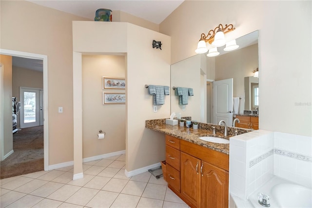 bathroom featuring baseboards, a garden tub, tile patterned flooring, and vanity