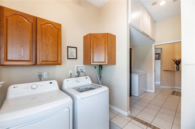 laundry room with light tile patterned flooring, cabinet space, washing machine and dryer, baseboards, and visible vents