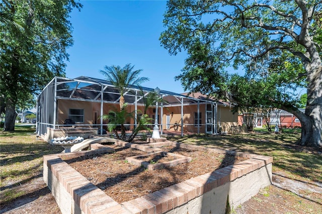 rear view of house with glass enclosure and stucco siding