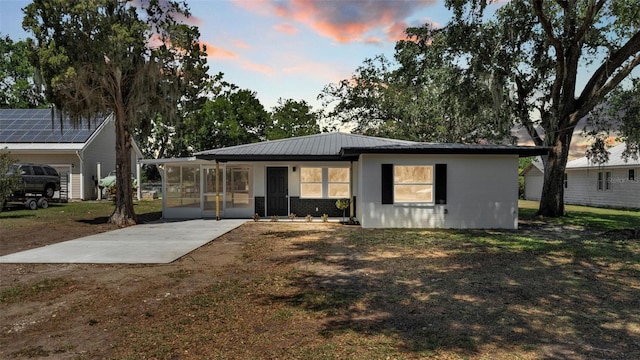 1650 W Mcleod St, Bartow, FL 33830 - view of front of home featuring a sunroom, metal roof, and a front lawn