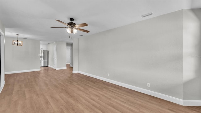 1650 W Mcleod St, Bartow, FL 33830 - unfurnished living room with light wood-style flooring, a ceiling fan, baseboards, and a chandelier