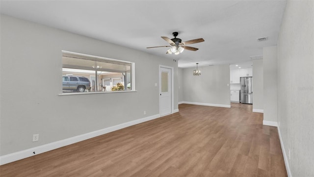 1650 W Mcleod St, Bartow, FL 33830 - unfurnished living room featuring ceiling fan, a chandelier, light wood-type flooring, and baseboards