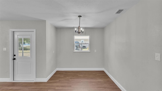 1650 W Mcleod St, Bartow, FL 33830 - unfurnished dining area with wood finished floors, a chandelier, and baseboards