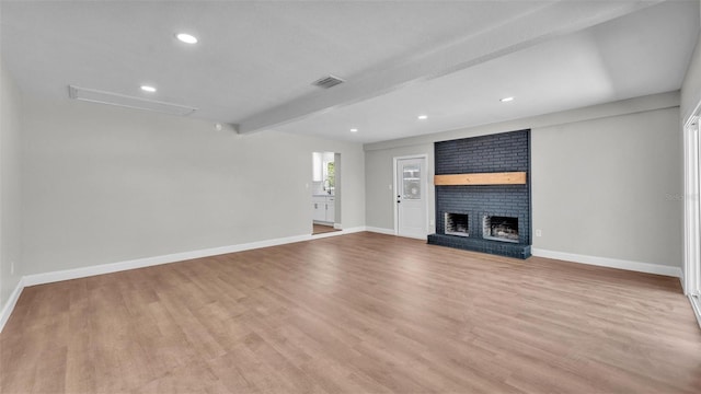 1650 W Mcleod St, Bartow, FL 33830 - unfurnished living room with baseboards, light wood finished floors, a brick fireplace, beam ceiling, and recessed lighting