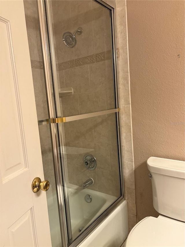 1135 Palace Pl, Lakeland, FL 33813 - bathroom featuring bath / shower combo with glass door and a textured wall