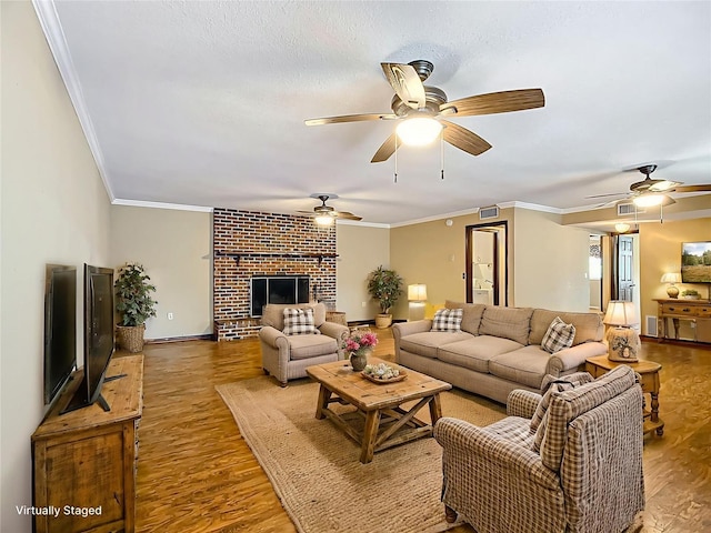 1135 Palace Pl, Lakeland, FL 33813 - living room featuring wood finished floors, a ceiling fan, crown molding, and a brick fireplace