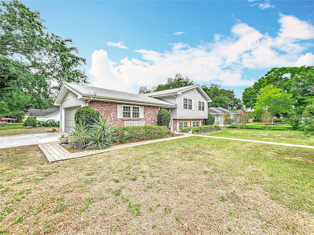 1135 Palace Pl, Lakeland, FL 33813 - tri-level home featuring brick siding, a front lawn, concrete driveway, an attached garage, and a metal roof