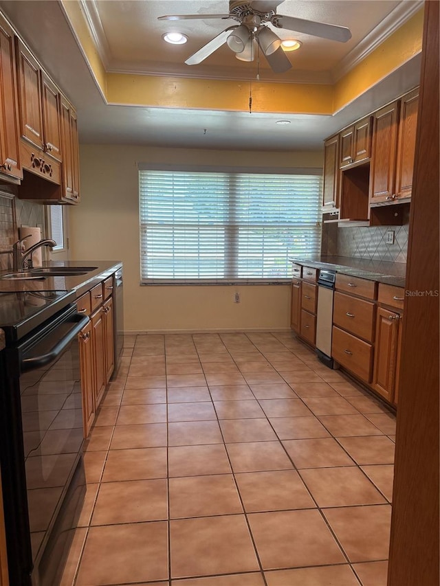 1135 Palace Pl, Lakeland, FL 33813 - kitchen featuring a tray ceiling, black range with electric cooktop, crown molding, decorative backsplash, and ceiling fan
