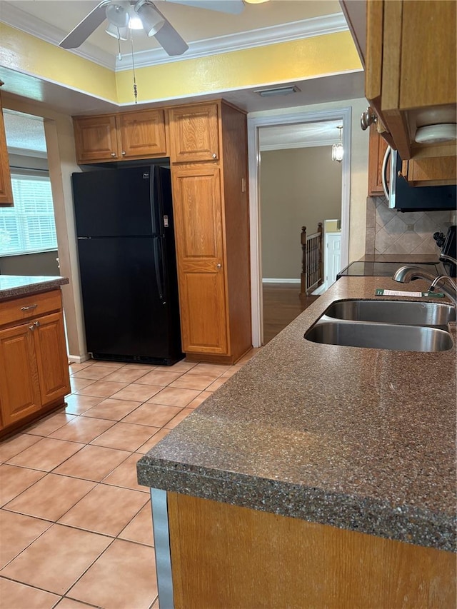 1135 Palace Pl, Lakeland, FL 33813 - kitchen featuring freestanding refrigerator, crown molding, ceiling fan, stainless steel microwave, and light tile patterned floors