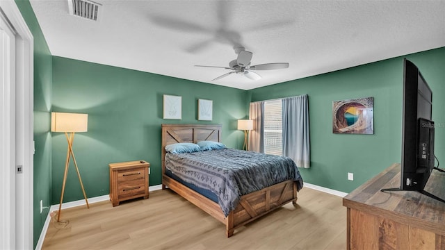 3273 Sennett Cir, Oxford, FL 34484 - bedroom featuring a textured ceiling, visible vents, baseboards, wood finished floors, and a ceiling fan