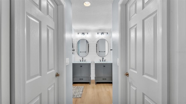 3273 Sennett Cir, Oxford, FL 34484 - bathroom with wood finished floors, vanity, and a textured ceiling