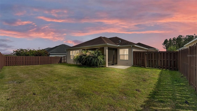 3273 Sennett Cir, Oxford, FL 34484 - rear view of property featuring a fenced backyard, a lawn, and stucco siding