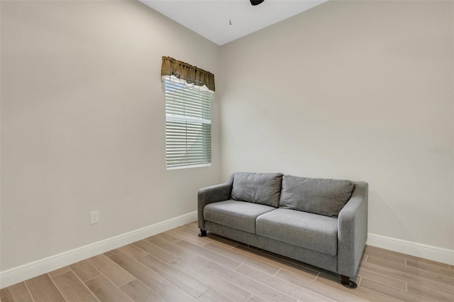 sitting room featuring light wood-type flooring, baseboards, and ceiling fan