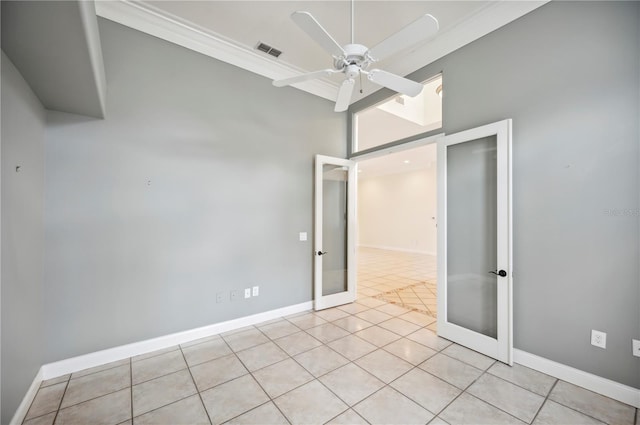 spare room featuring french doors, a ceiling fan, light tile patterned flooring, a towering ceiling, and baseboards