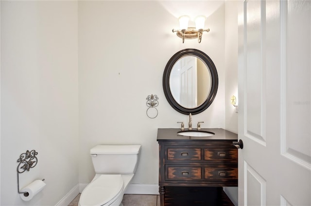 half bathroom with toilet, vanity, baseboards, and tile patterned flooring
