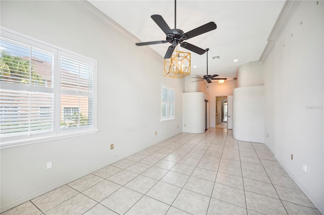 unfurnished room featuring a ceiling fan, light tile patterned flooring, crown molding, and a chandelier