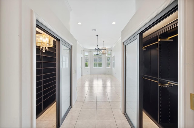 hallway with a chandelier, light tile patterned floors, crown molding, and recessed lighting
