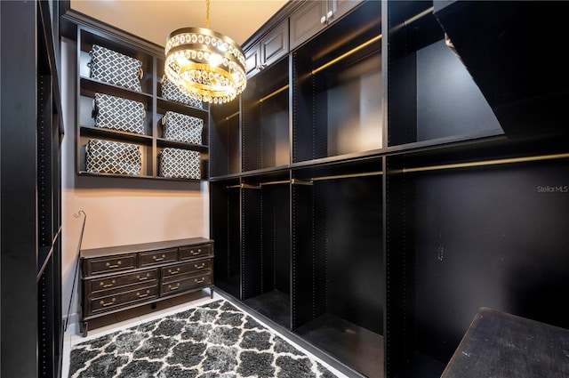 spacious closet with a chandelier