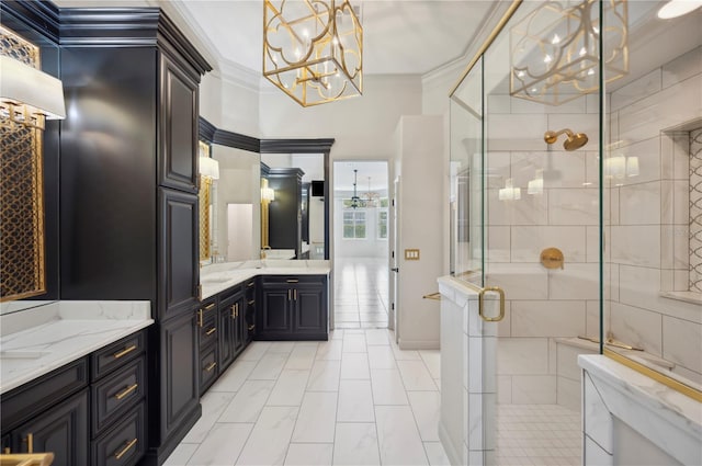 full bath with a chandelier, ornamental molding, a shower stall, two vanities, and marble look tiles