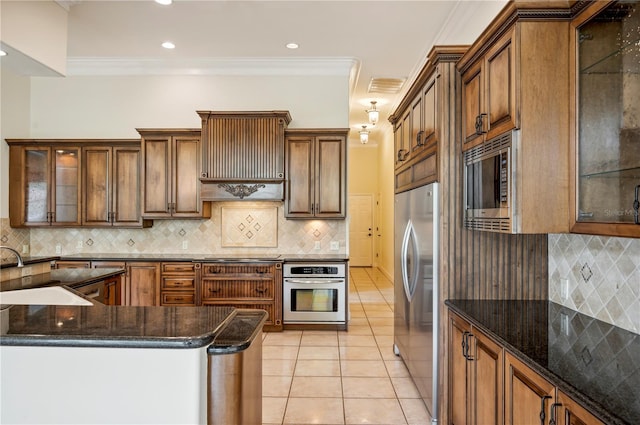 kitchen with appliances with stainless steel finishes, a sink, tasteful backsplash, light tile patterned flooring, and ornamental molding