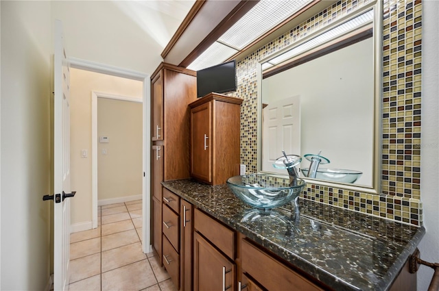 bathroom with tasteful backsplash, tile patterned flooring, and vanity