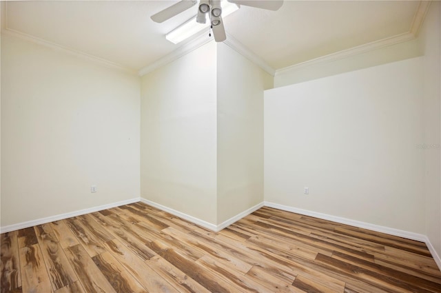 empty room with a ceiling fan, crown molding, light wood-type flooring, and baseboards
