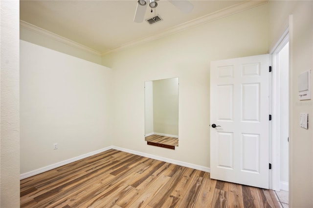 unfurnished room featuring crown molding, baseboards, wood finished floors, and ceiling fan