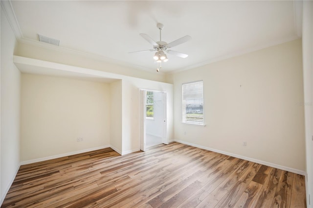 spare room with crown molding, light wood-style flooring, ceiling fan, and baseboards