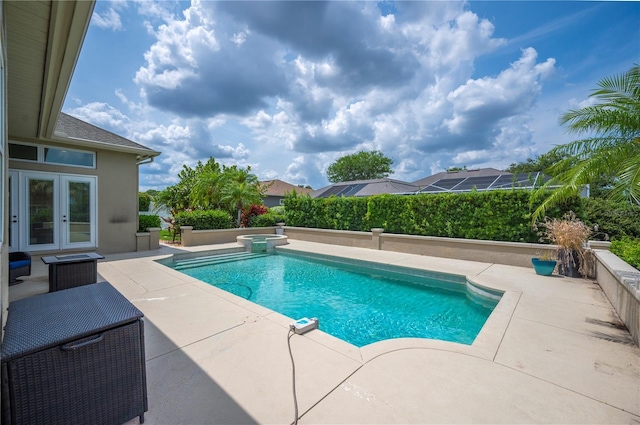 view of swimming pool featuring a patio, french doors, and a pool with connected hot tub