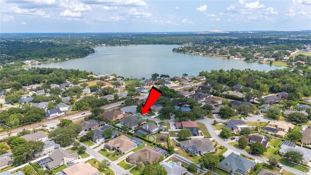 aerial view of property and surrounding area featuring a large body of water and nearby suburban area