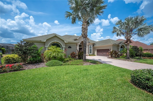 ranch-style home with stucco siding, a garage, a front yard, and driveway