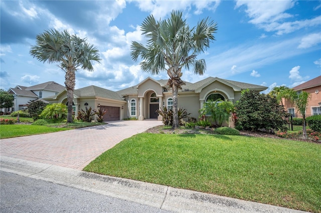 view of front of house featuring stucco siding, a garage, and decorative driveway