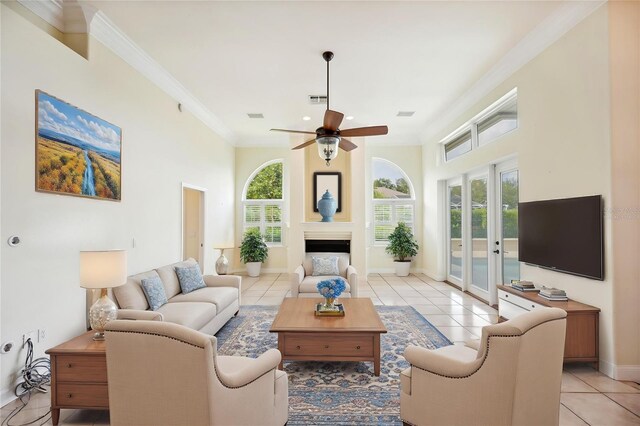 715 Hanover Ct, Lakeland, FL 33813 - living room featuring light tile patterned floors, ceiling fan, crown molding, baseboards, and a high ceiling