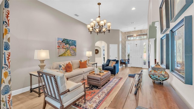 6372 English Creek Dr, Lakeland, FL 33811 - living room featuring a chandelier, arched walkways, a towering ceiling, light wood-style flooring, and recessed lighting