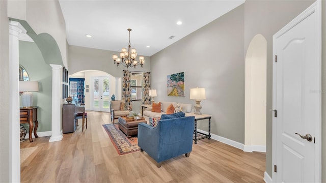 6372 English Creek Dr, Lakeland, FL 33811 - living room featuring arched walkways, light wood-style floors, recessed lighting, a chandelier, and ornate columns